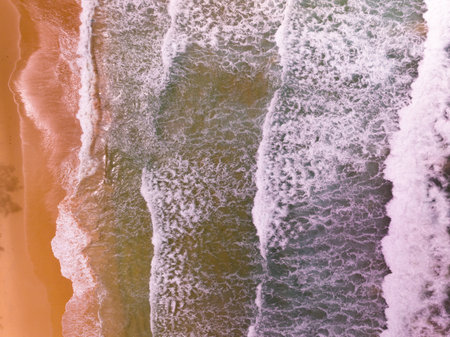 Aerial view of Waves crashing on sandy shore,Sea surface ocean waves background,Top view beach backgroundの写真素材