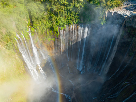 Aerial view of Panorama Tumpak Sewu Waterfalls also known as Coban Sewu.Beautiful rainbow and fog,Tumpak Sewu Waterfalls are a tourist attraction in East Java, Indonesia.Amazing travel destinationの写真素材
