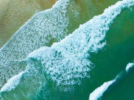 Aerial view sandy beach and waves crashing on sandy shore, Beautiful tropical sea surface backgroundの写真素材