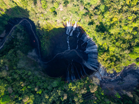 Aerial view of Panorama Tumpak Sewu Waterfalls also known as Coban Sewu.Beautiful rainbow and fog,Tumpak Sewu Waterfalls are a tourist attraction in East Java, Indonesia.Amazing travel destinationの写真素材