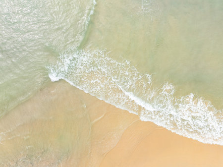 Aerial view Beach waves crashing on sandy shore