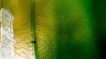 Aerial view Top down Waves crashing on sandy shore,Dark sea surface in summer day...