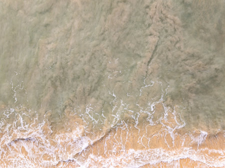 Top view beach with waves crashing on sandy shore,Beautiful waves sea surface in summer seascape background,Amazing beach colorful water backgroundの写真素材