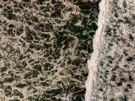 Top view beach with waves crashing on sandy shore Beautiful waves sea surface in summer seascape backgroundの写真素材