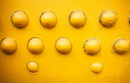 yellow metal plate with boltsの写真素材