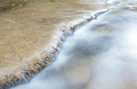 water flowing down from the rocksの写真素材