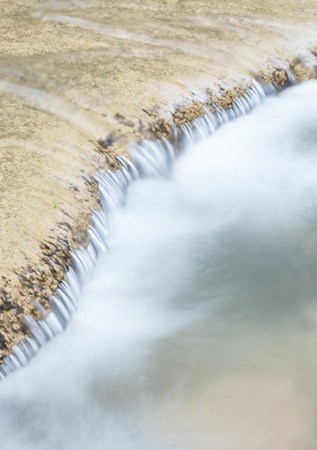 water flowing down from the rocksの写真素材