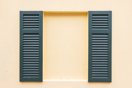 green window on a yellow wallの写真素材