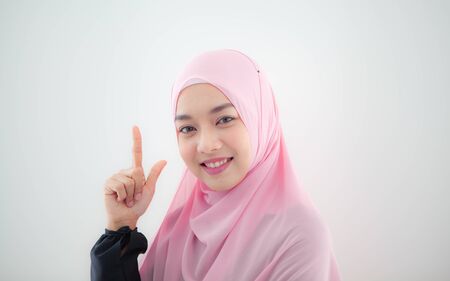 Portrait of a beautiful woman Muslims in Asia wearing pink hijab are enjoying a bright smile on white backgroung.の写真素材