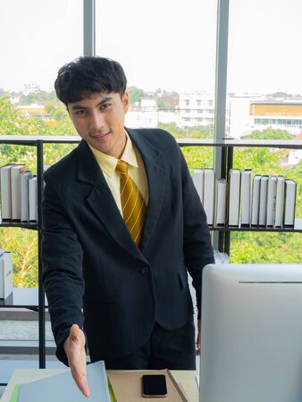A young businessman congratulates a negotiator on a successful business deal within a modern office. Great job concept.の写真素材