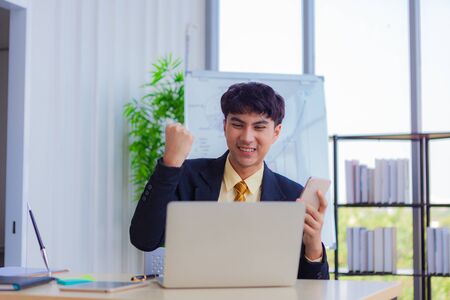 Young businessmen are greeting business partners on a computer screen via teleconferencingの写真素材