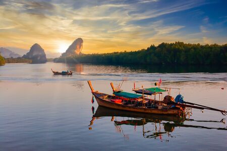 The beautiful scenery of Phang Nga Bay in the morning when the traditional fishing boats returned from fishing to the shore to unload the productsの写真素材