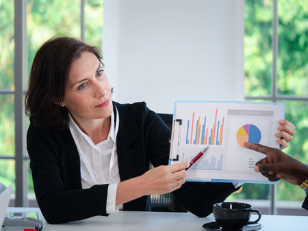 Portrait of businesswoman leader presenters showing growth graphics and taking a business conversation at office conference meetings. colleagues discussing and consulting conceptの写真素材