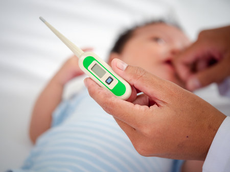 Baby illness medicine flu fever and thermometer, a doctor checks the temperature of the ill baby. Digital thermometer to measure the heat temperature of a sick child. Baby fever conceptの写真素材