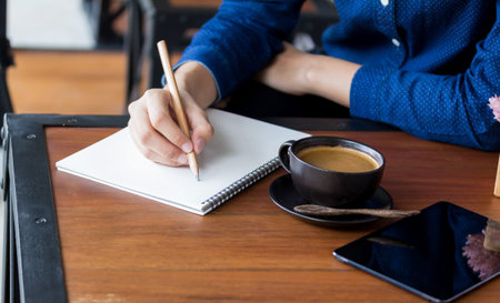 Young woman student writes information from portable net-book while prepare for lectures in...