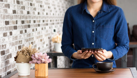 women using a digital tablet  at a coffee shop. Young man and woman looking at touch screen  and...