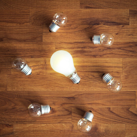 glowing bulb uniqueness concept on brown wooden table