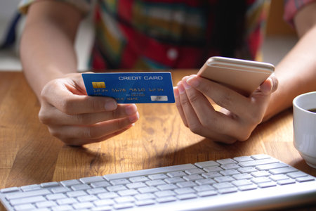 female hold credit cards  use mobile phones, online shopping or online payments.の写真素材