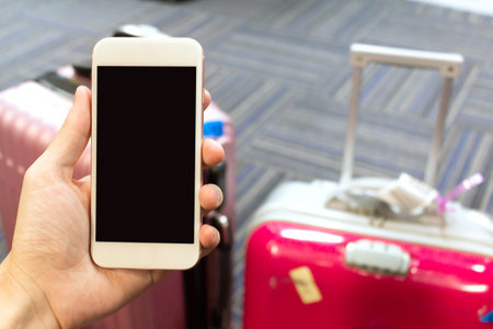 Mobile and tourism The background is a red suitcase.の写真素材