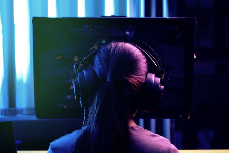 back view female gaming in steamer live and use online media  with neon night lighting