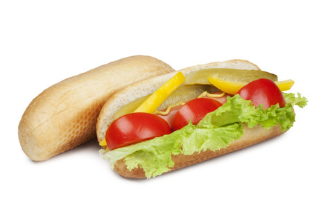 hot dog with fresh tomato, salad, yellow peppers and pickled cucumber seasoned with mustard and bun for hot dog  isolated on a white backgroundの写真素材