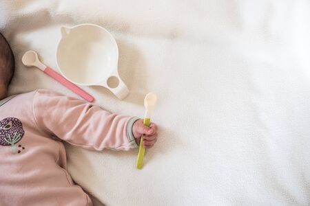 Blank Baby bowl , spoon and baby hand : concept of baby food feedingの写真素材