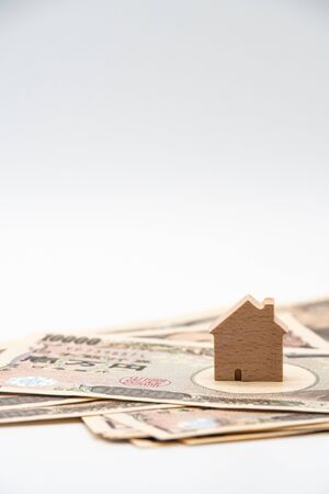 Close up little wooden house on japanese currency yen money banknote. Background concept for japan  real estate industry economy.の写真素材