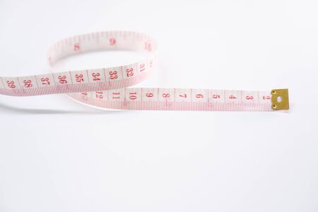 Measure tape on white background. Concept for diet  weight lose and measurement.の写真素材