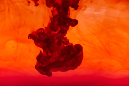 Close up red color ink Fluid liquid and smoke Abstract  background. Color drop flowing in water.