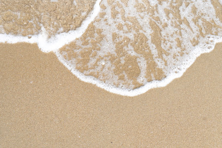 Close up ocean wave bubble on sandy beach. Background for vacation holiday and natural feeling.