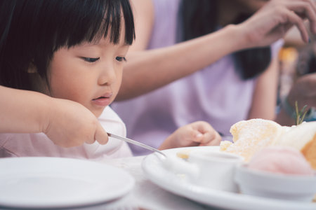 Asain cute girl eat dessert pancake with spoon. Concept for kid and family lifestyle.の写真素材