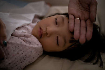 Mother checks the temperature of her kid. Concept for health and take care of children.の写真素材