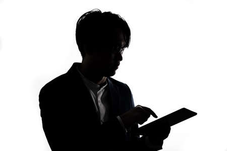 Silhouette of businessman use tablet isolate on  white background. Concept for business and online technology.の写真素材