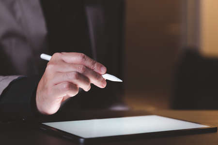 Close up hand of businessman use pen with tablet. Concept of technology for business.の写真素材