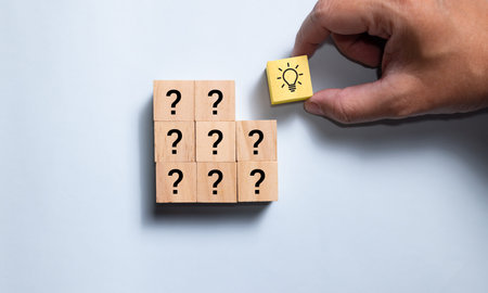 Top view wooden blocks set to step from question to idea. Concept for creative and design solution.