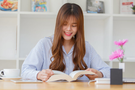 Beautiful women sit enjoy reading the book at the cafe.の写真素材