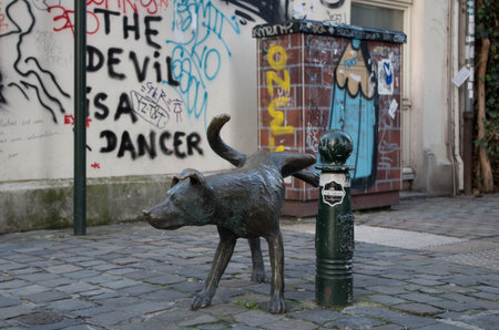 The famous dog pissing statues in Brussels, in front of a wall with graffitiの写真素材