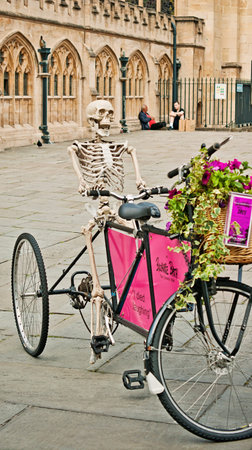 A skeletor in a bicycle with a basket of flower to promotion a comedy  in city center of Bath Spa, Somerset, Englandのeditorial素材