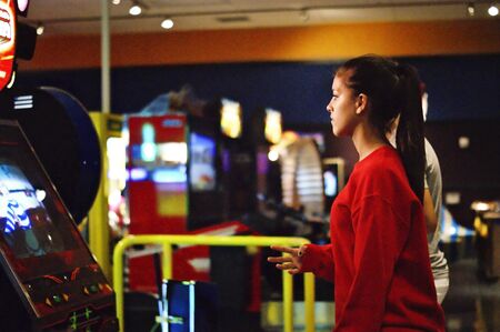 A young girl is playing in the dance machineの写真素材