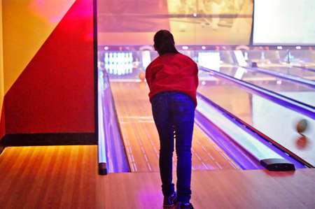 A young girl is playing bowling in a winter dayの写真素材