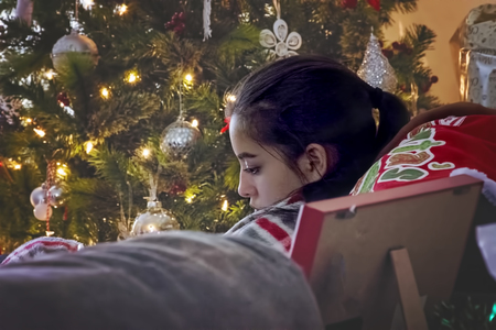 girl relaxing next to a Christmas treeの写真素材