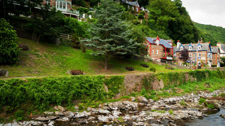 A row of houses offering bed and breakfast accommodation alongside the East Lyn River in Lynmouth in North Devon England UKの写真素材