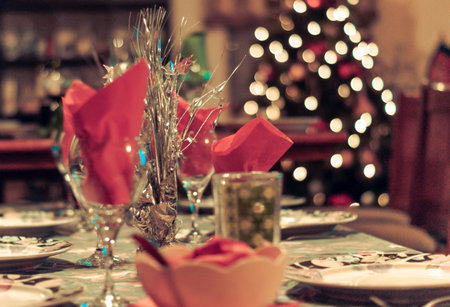Table set up  ready for Christmas dinner with a tree in the corner