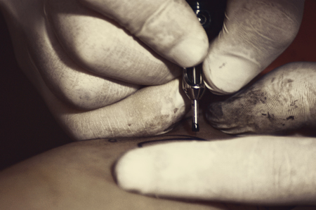 Young woman getting tatoo on her legの写真素材