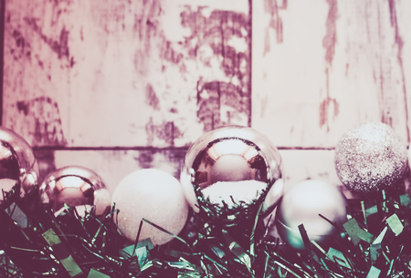 silver and white baubles and green garlandas decoration for Christmas on a white wooden background with copy-spaceの写真素材
