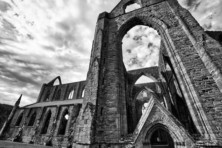 Black and white photo of The ruins of Tintern Abbey, founded by Walter de Clare, Lord of Chepstow. It is situated adjacent to the village of Tintern in Monmouthshire, Wales, UK.の写真素材