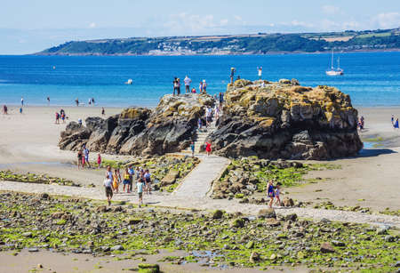 25 July 2018: Marazion, Cornwall, UK- People resting on the Chapel Rock.The rock is the site of an ancient oratory / chapel.The Chapel was destroyed by the Royalists in 1645 .Chapel Rock is one of the sites used to land passengers from the boats to theのeditorial素材