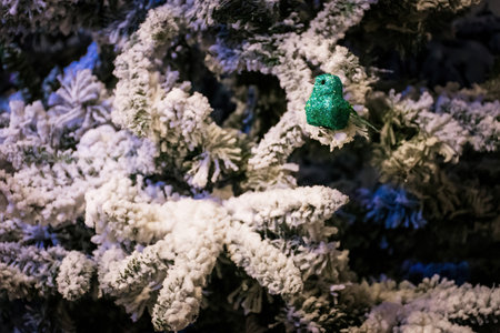 Green Glitter Robin in a snowy tree. Christmas decorations on sale in a garden centre, near Lacock, Englandの写真素材