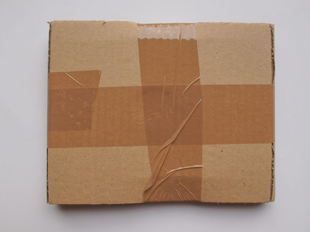 cardboard parcel sealed with adhesive tape useful as shipping concept or as background