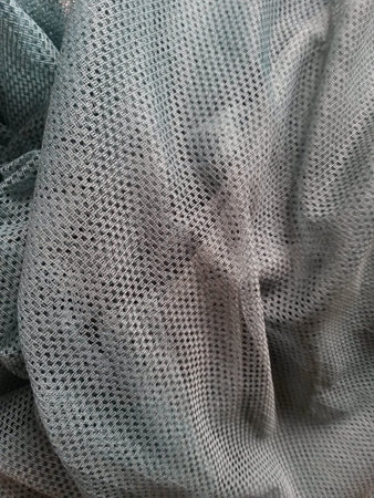 grey fishnet fabric texture useful as a backgroundの写真素材